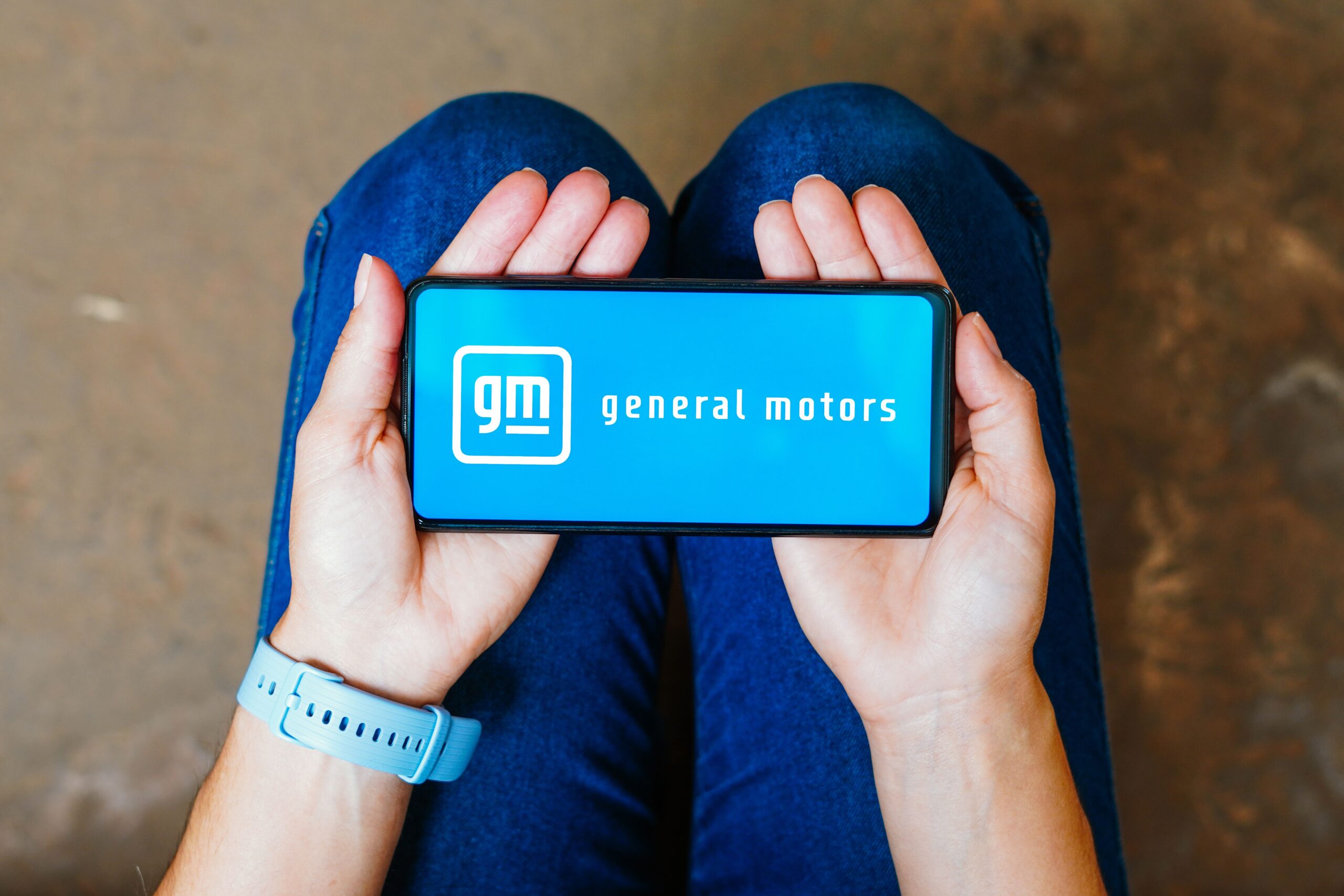 In this photo illustration, the General Motors Company (GM) logo is displayed on a smartphone screen.