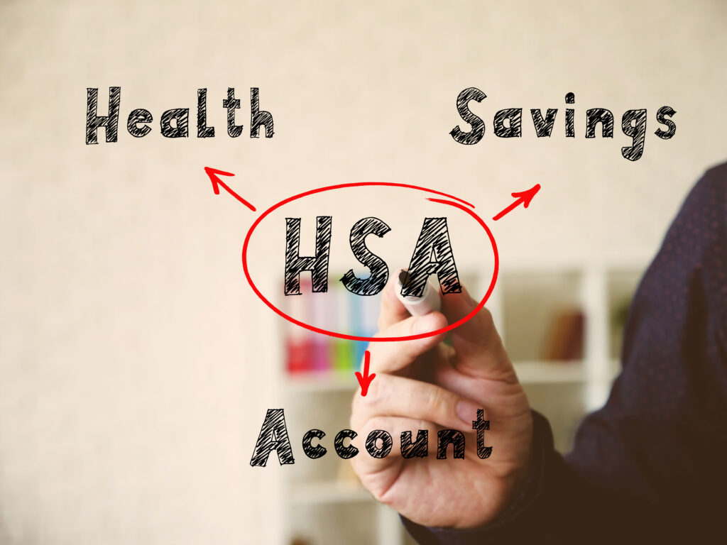 HSA Health Savings Account note. Young bussines man in a suit writing on an background.